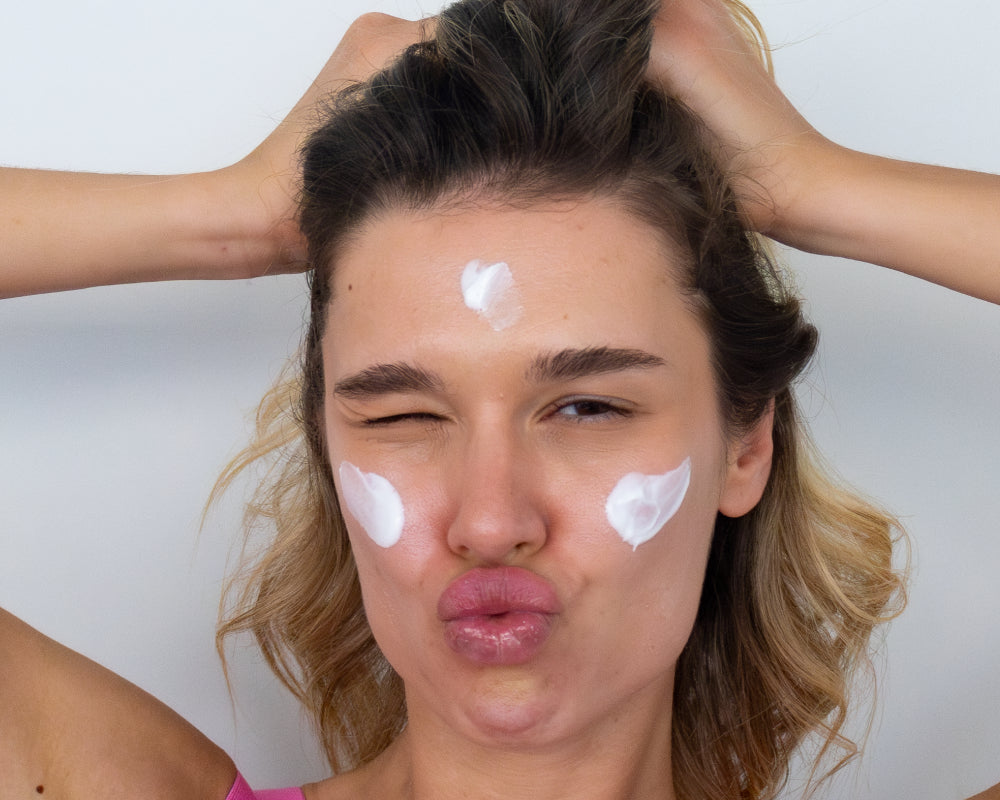 Woman with NOISS Glass Skin Sleeping Mask cream dots on forehead and cheeks
