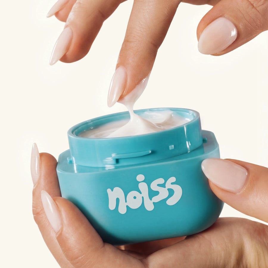 Hand scooping NOISS Glass Skin Sleeping Mask from open jar